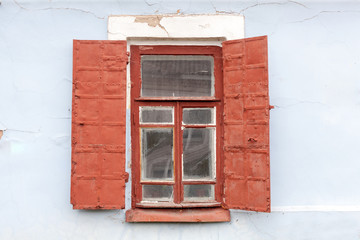 Old wooden window with metal shutters