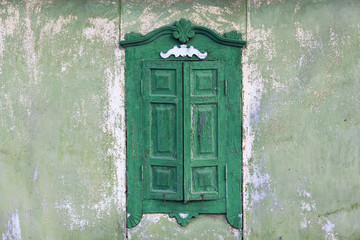 Old wooden window with closed wooden shutters