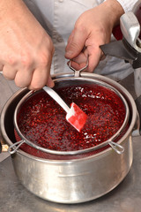 Preparando mermelada de moras, colando crema de moras.