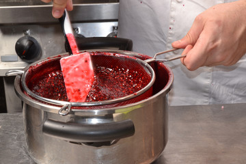 Preparando mermelada de moras, colando crema de moras.