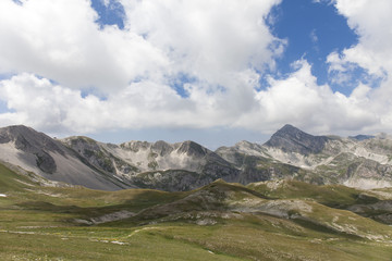 Panorama montano. Catena montuosa degli Appennini, Italia. Grandi nuvole bianche nel cielo blu