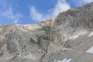 Sentieri montani sugli Appenini. Cime rocciose, sfondo blu con nuvole bianche