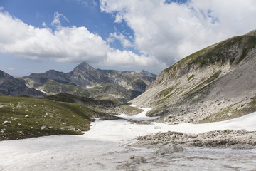 Panorama montano. Catena montuosa degli Appennini. Italia. Neve in primo piano, nuvole bianche...