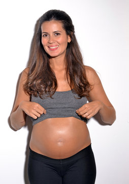 Mujer latina embarazada feliz mostrando la barriga