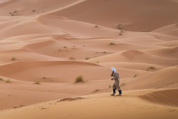 Fototapeta na wymiar a touareg walking in the desert