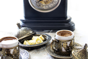 Turkish coffee with delight and traditional copper serving set, vintage clock