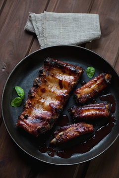 Above view of baked pork ribs with sauce in a frying pan