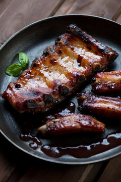 Baked pork ribs in a frying pan, close-up, selective focus