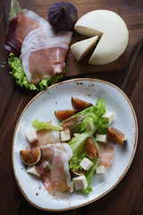 Salad with fresh fig fruits, ham and cheese, above view, closeup