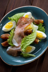 Salad with ham, ripe figs and eggs. Close-up, selective focus