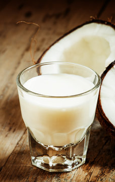 Coconut milk and fresh coconut on the old wooden background, sel