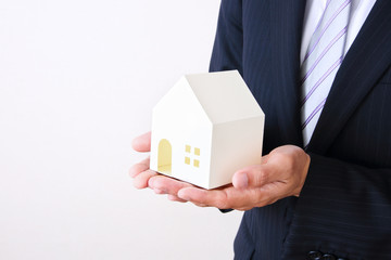 Businessman holding model house