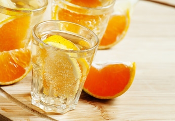 Tangerine and lemon drink soda on a wooden table, selective focu
