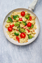 Tortellini with tomatoes and vegetables sauce in white frying  pan