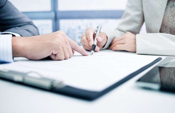 Female hand signing contract.