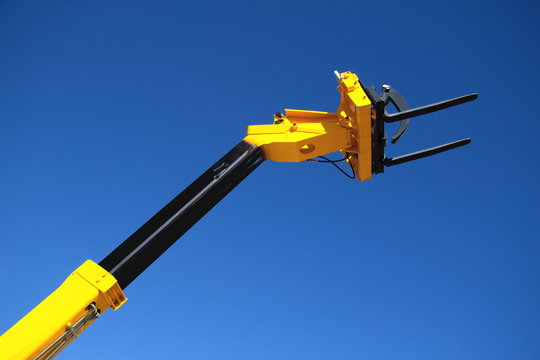 Pointing forklift against the sky