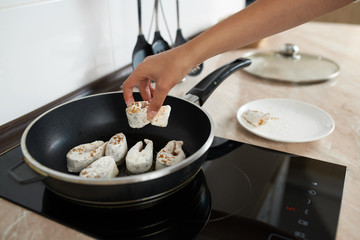 girl in kitchen fry fish pan