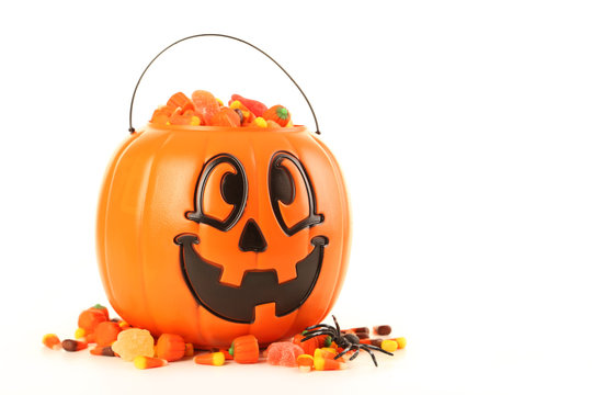 Halloween Pumpkin Basket Full Of Candies Isolated On A White