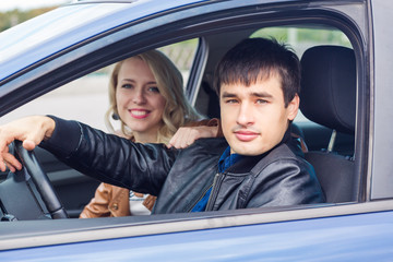 Happy young couple sitting in the car