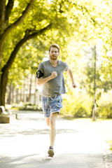 Young man running in the autumn park