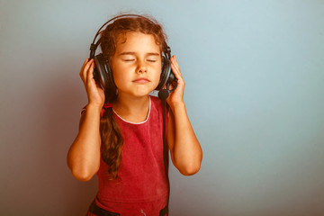 Teen girl child eyes closed listening to music with big headphon