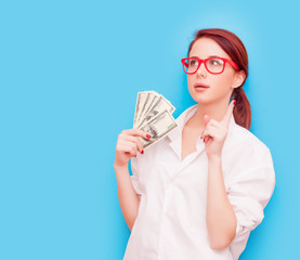 Portrait of redhead woman in red glasses with money