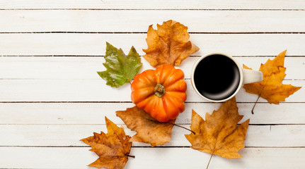 Cup and pumpkin with leafs