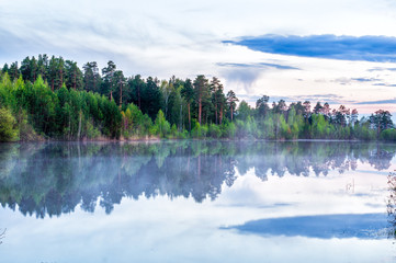 туманное утро на водоеме с отражением леса в воде, Россия, Урал © 7ynp100