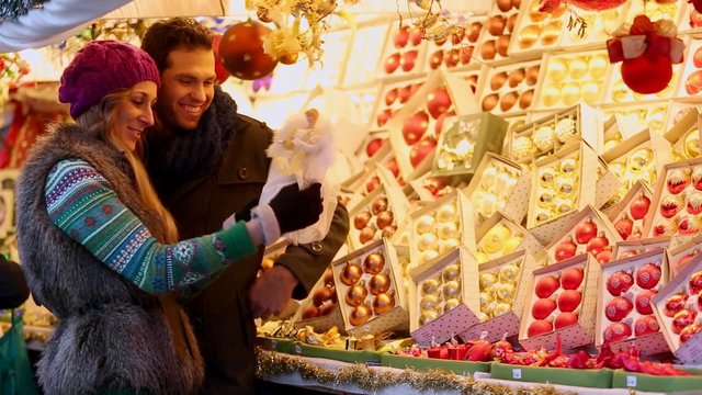 Frau und Mann kaufen Dekoration auf Weihnachtsmarkt