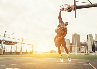 Street basketball player performing power slum dunk