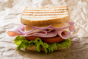 toast ham sandwich on brown paper