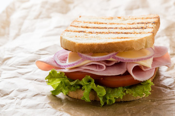 toast ham sandwich on brown paper