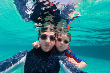 Obraz na płótnie Canvas Father and son swimming underwater