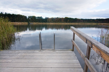 Fototapeta na wymiar Wooden jetty and ladder into lake