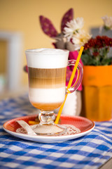beautiful cappuccino, latte,coffee in a glass Cup on a checkered tablecloth