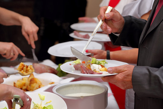 Chef serves portions of food at a party
