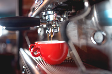 Automatic espresso machine pouring coffee in cups at restaurant or pub. Barista concept with...