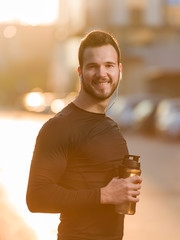 Handsome sporty man  tired runner resting after evening jog, fit