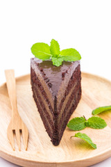 Chocolate cake slice in wooden plate.