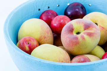 Juicy peaches and apricots in wooden bowl