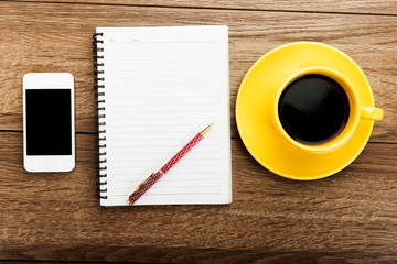 Workplace with phone,notebook, pen and cup of coffee on work tab