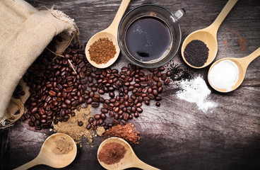 grated coffee in spoon on roasted coffee beans background