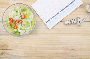 healthy eating, dieting, slimming and weigh loss concept - close up of salad, measuring tape