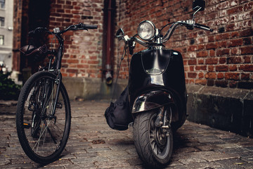 Retro moto scooter and black bicycle.