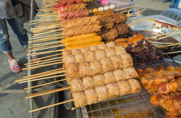 Many type of street foods on grill in local town center,Thailand