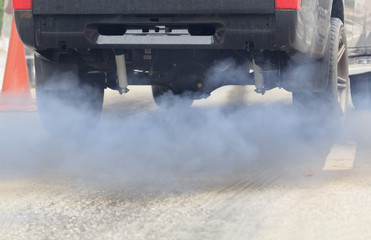 Air pollution from vehicle exhaust pipe on road