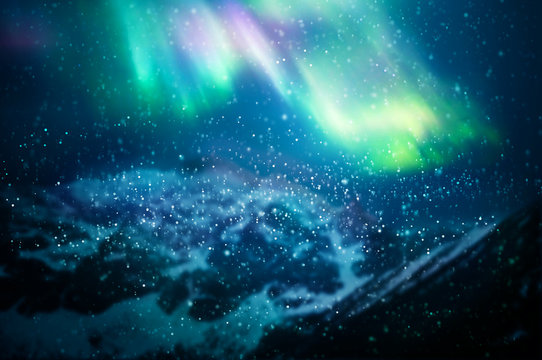 Snow falling against aurora borealis - focus on snowflakes