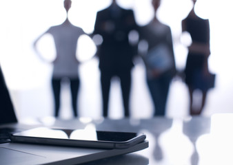 Laptop  computer on  desk ,  businesspeople standing in the