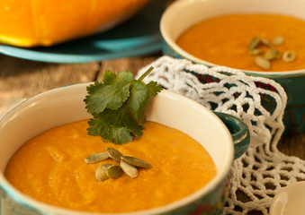 Traditional pumpkin soup on lace doily and wooden table