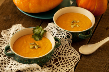 Traditional pumpkin soup on lace doily and wooden table